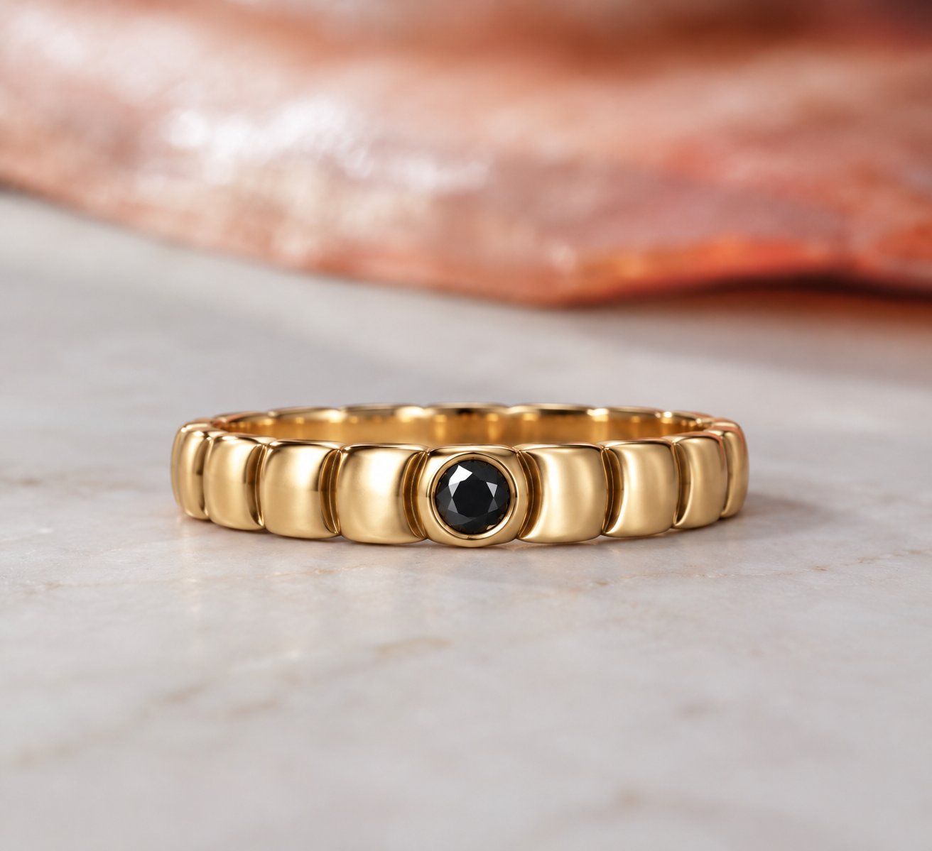 Gravitational Wave wedding band in yellow gold, a segmented wave-shaped band with one bezel-set black diamond