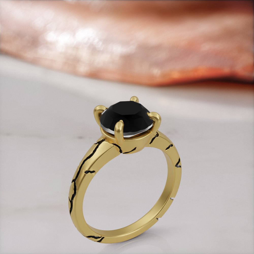 Kintsugi engagement ring in yellow gold with a round black diamond and black-filled cracks across the band, three-quarter view